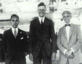 Edsel Ford, Charles Lindbergh, and Henry Ford pose in the Ford hangar during Lindbergh's August 1927 visit.
