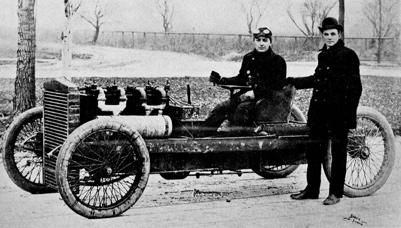 Ford (standing) launched Barney Oldfield's career in 1902. The 999 racer pictured.